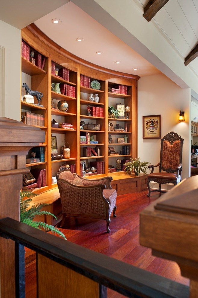 Example of a mid-sized classic medium tone wood floor and brown floor home office library design in Nashville with white walls and no fireplace
