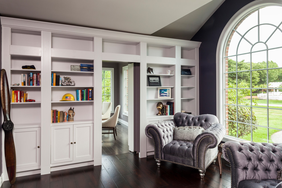 Inspiration pour un bureau traditionnel de taille moyenne avec une bibliothèque ou un coin lecture, un mur violet, parquet foncé, aucune cheminée et un sol marron.