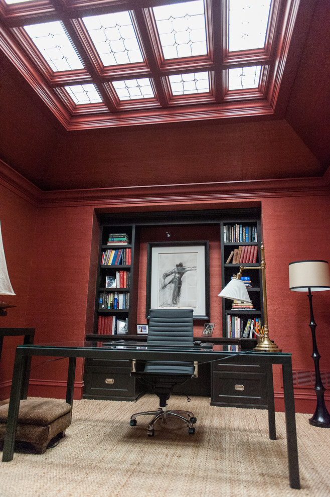 Inredning av ett klassiskt stort hemmabibliotek, med röda väggar, heltäckningsmatta och ett fristående skrivbord