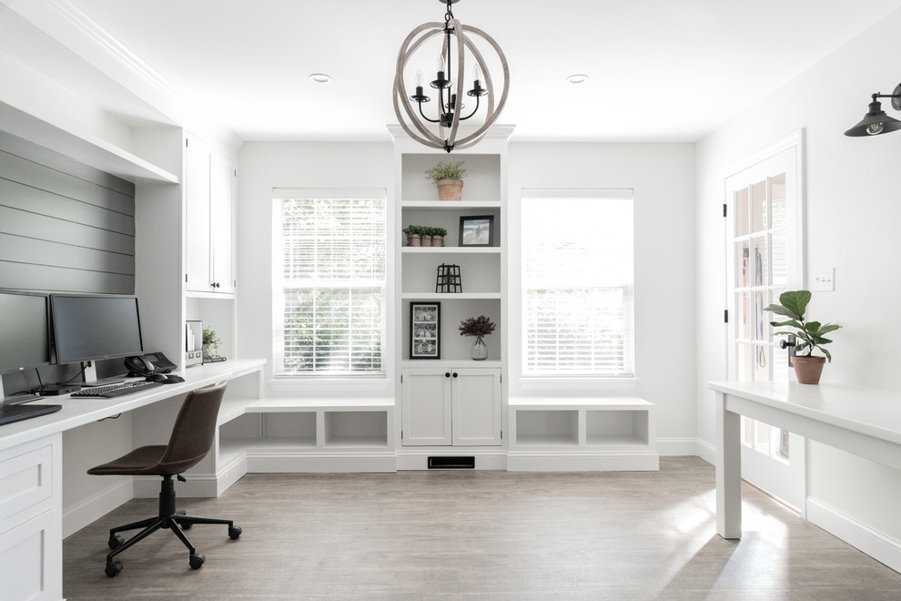 Photo of a traditional home office in Other with white walls, a built-in desk and beige floors.