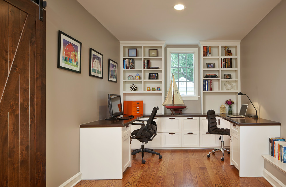 Home office - mid-sized traditional built-in desk medium tone wood floor and brown floor home office idea in Chicago with beige walls and no fireplace