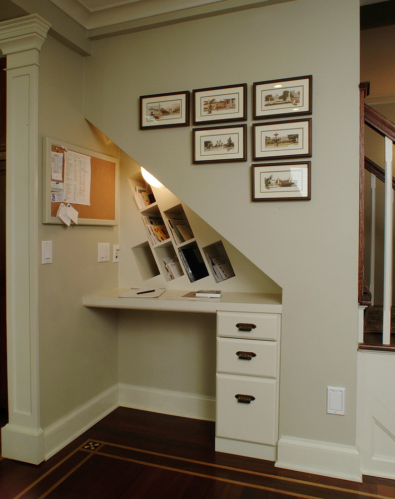 Foto de despacho tradicional pequeño con paredes beige, suelo de madera oscura, escritorio empotrado y suelo marrón