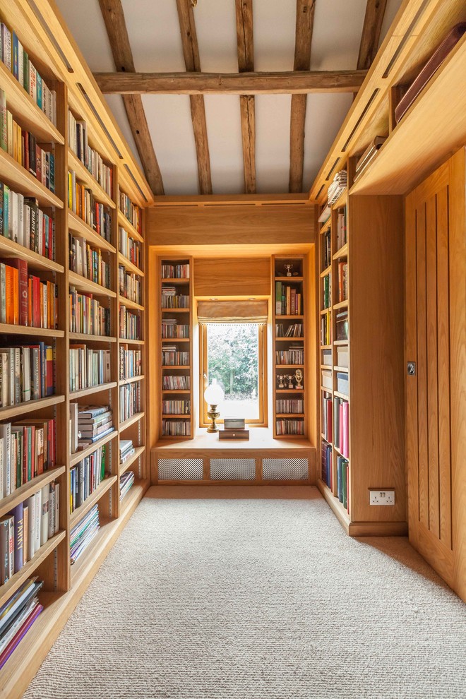 Aménagement d'une salle de séjour campagne avec une bibliothèque ou un coin lecture et moquette.