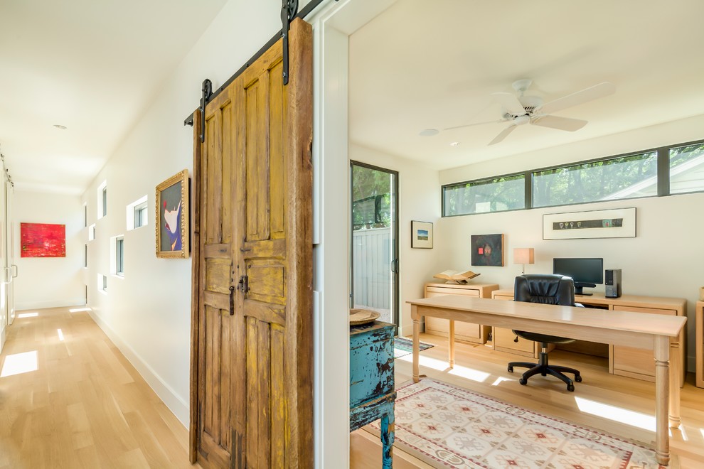 Study room - farmhouse freestanding desk light wood floor study room idea in Dallas with no fireplace and white walls