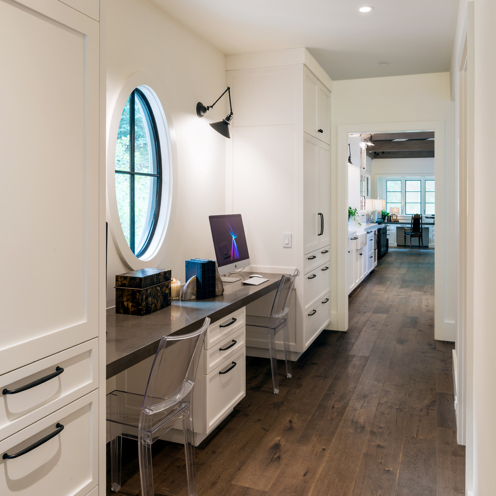 Ejemplo de despacho campestre de tamaño medio con paredes blancas, suelo de madera oscura y escritorio empotrado