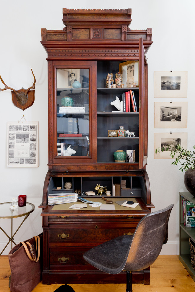 Diseño de despacho campestre con paredes blancas, suelo de madera clara y escritorio independiente