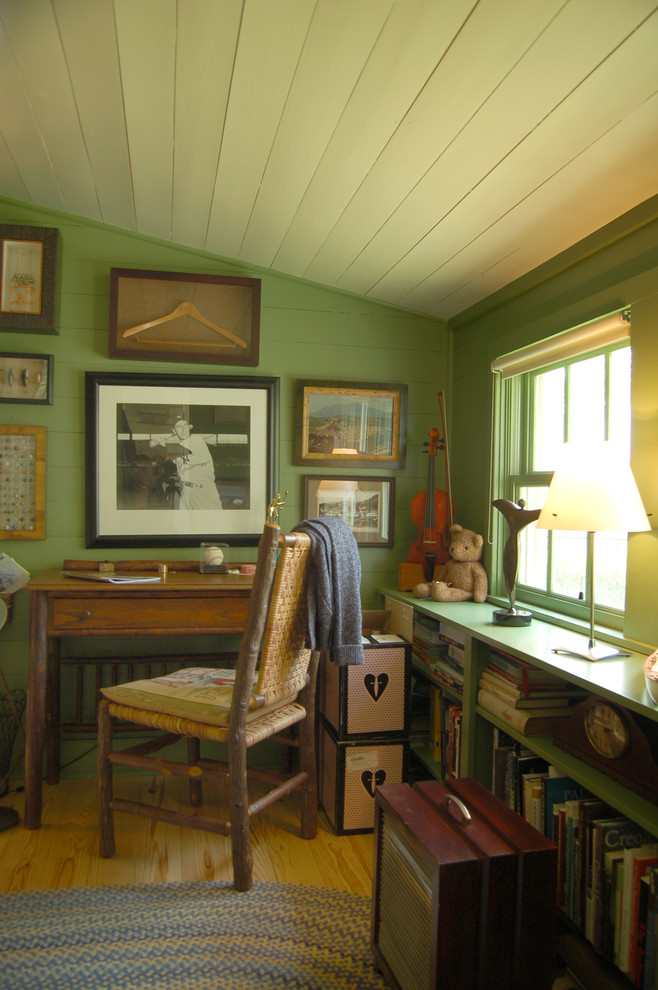 Country freestanding desk medium tone wood floor home office photo in Austin with green walls