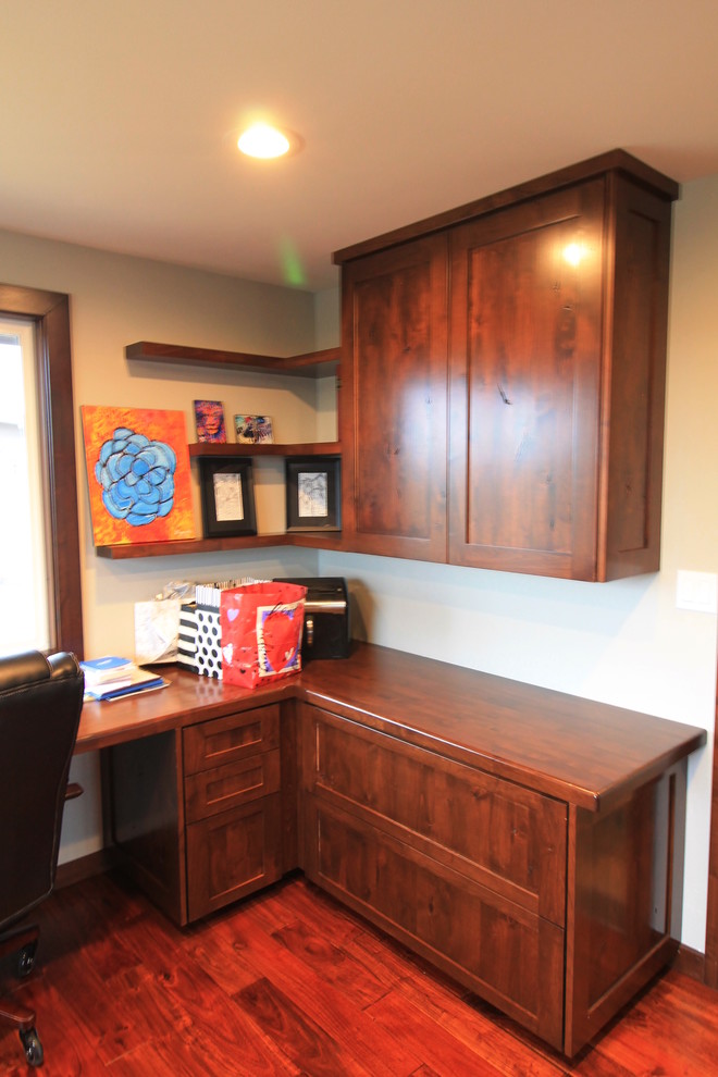 Foto de despacho de estilo de casa de campo grande sin chimenea con paredes beige, suelo de madera en tonos medios y escritorio empotrado