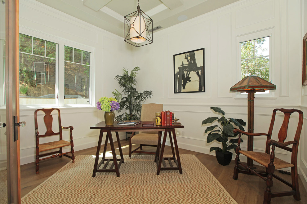 Foto de despacho de estilo de casa de campo de tamaño medio sin chimenea con paredes blancas, suelo de madera en tonos medios y escritorio independiente