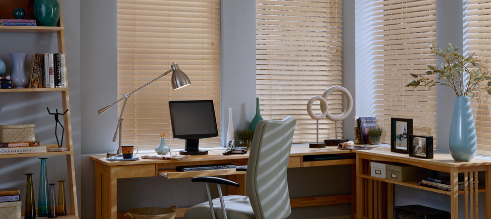 Ejemplo de despacho moderno de tamaño medio con paredes azules y escritorio independiente