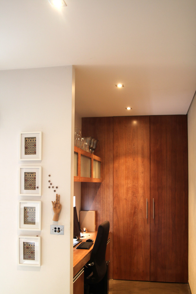Kleines Stilmix Arbeitszimmer mit Arbeitsplatz, beiger Wandfarbe, Betonboden und Einbau-Schreibtisch in Sonstige