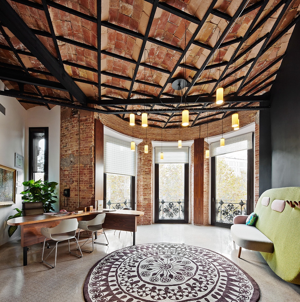 Großes Industrial Arbeitszimmer ohne Kamin mit weißer Wandfarbe, freistehendem Schreibtisch, Studio und Travertin in Barcelona