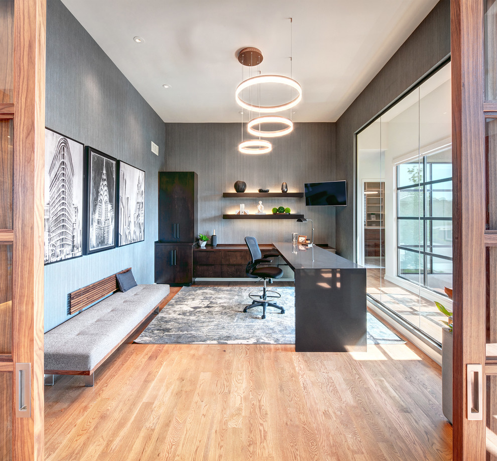 Foto de despacho contemporáneo con paredes grises, suelo de madera clara y escritorio independiente