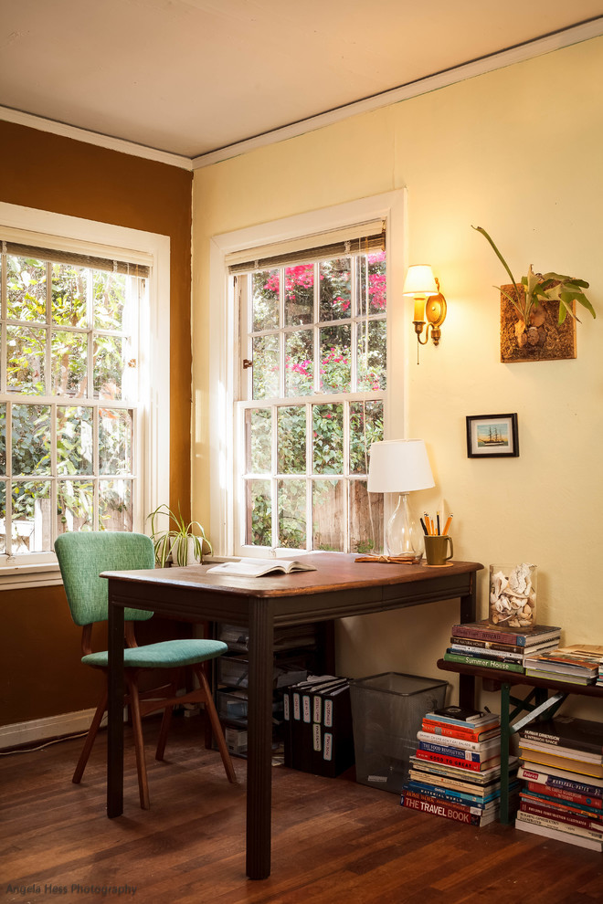 Diseño de despacho de estilo de casa de campo pequeño sin chimenea con paredes multicolor, suelo de madera en tonos medios y escritorio independiente