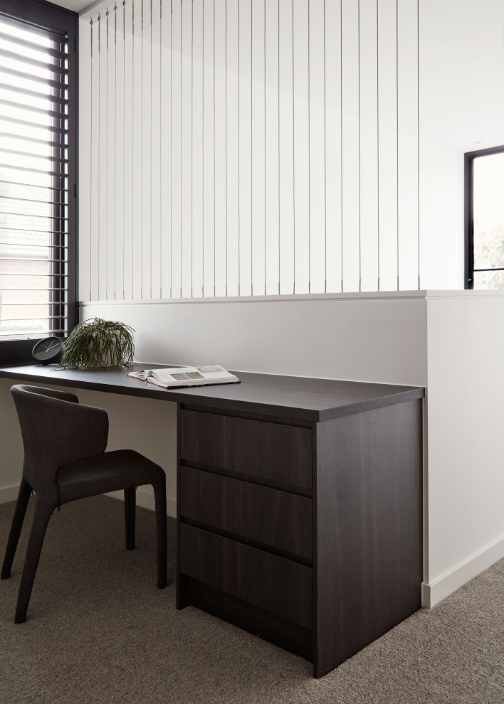 Immagine di un ufficio minimalista di medie dimensioni con pareti bianche, moquette, scrivania incassata e pavimento grigio