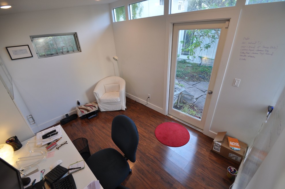 Inspiration för små moderna arbetsrum, med vita väggar, laminatgolv och ett fristående skrivbord