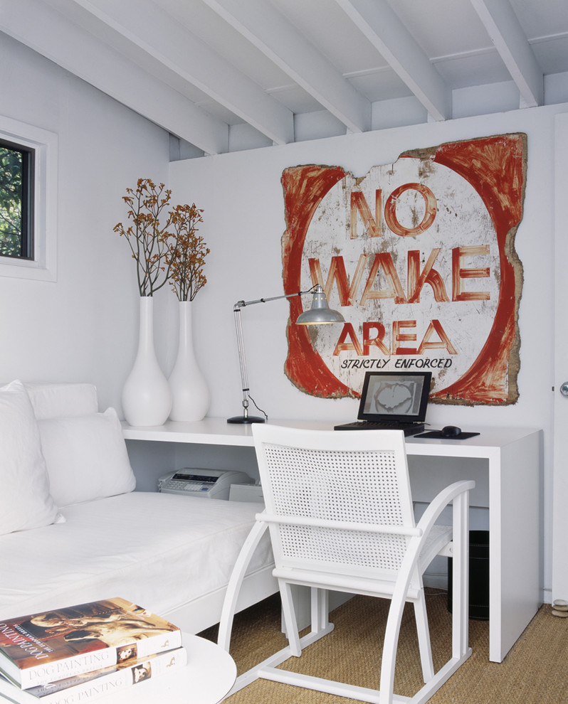 Foto di uno studio minimal con pareti bianche, moquette e scrivania autoportante