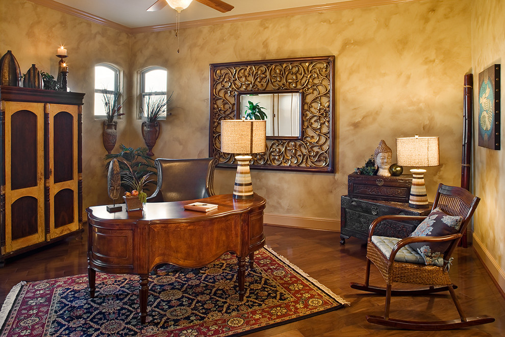 Mediterranes Arbeitszimmer mit beiger Wandfarbe, dunklem Holzboden und freistehendem Schreibtisch in Austin