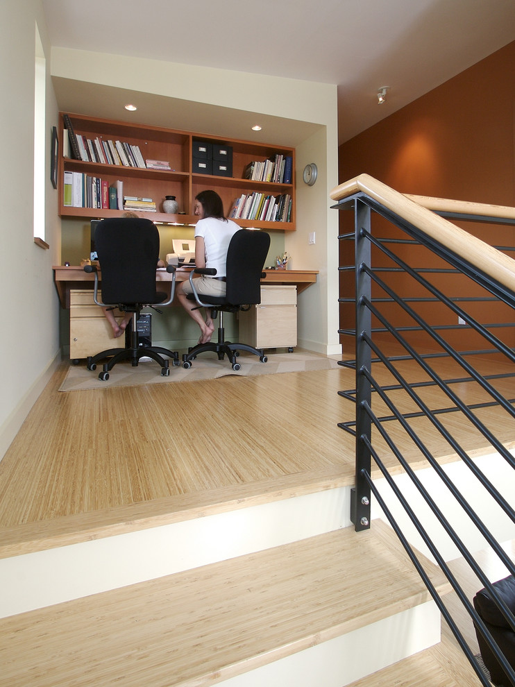 Ejemplo de despacho minimalista con paredes marrones, suelo de madera clara y escritorio empotrado