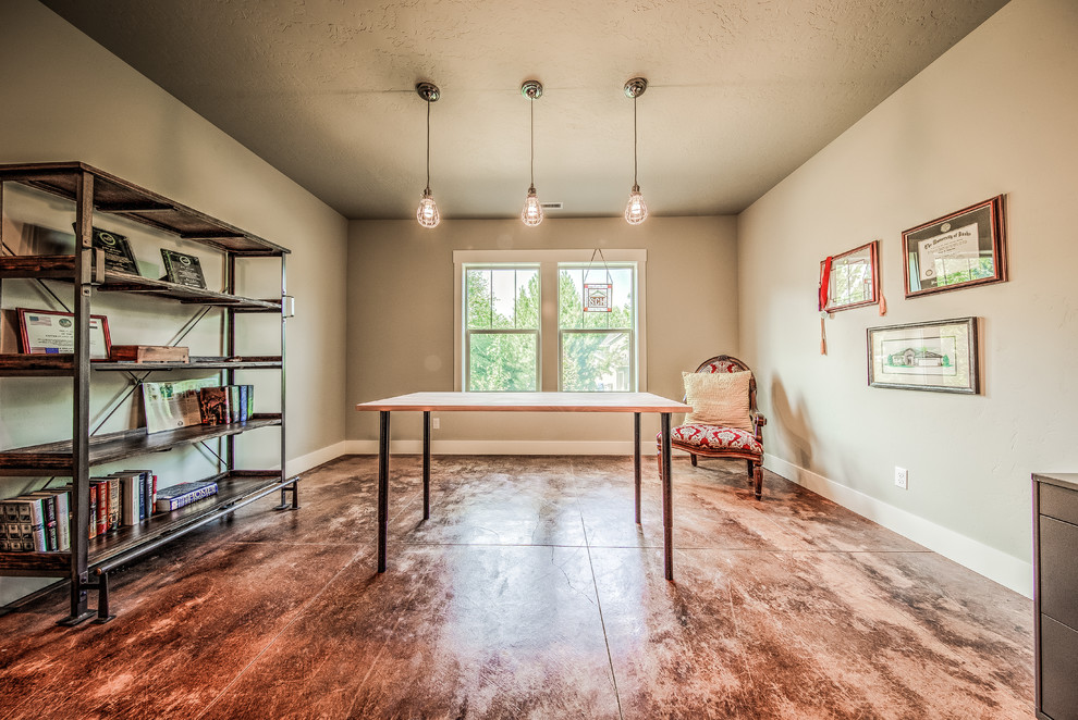 Geräumiges Industrial Arbeitszimmer ohne Kamin mit grauer Wandfarbe, Betonboden und freistehendem Schreibtisch in Boise