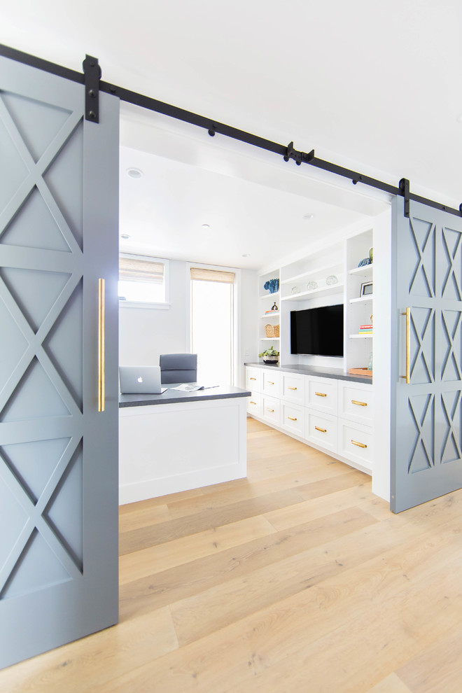 Mittelgroßes Landhausstil Arbeitszimmer mit weißer Wandfarbe, braunem Holzboden, Einbau-Schreibtisch und beigem Boden in Orange County