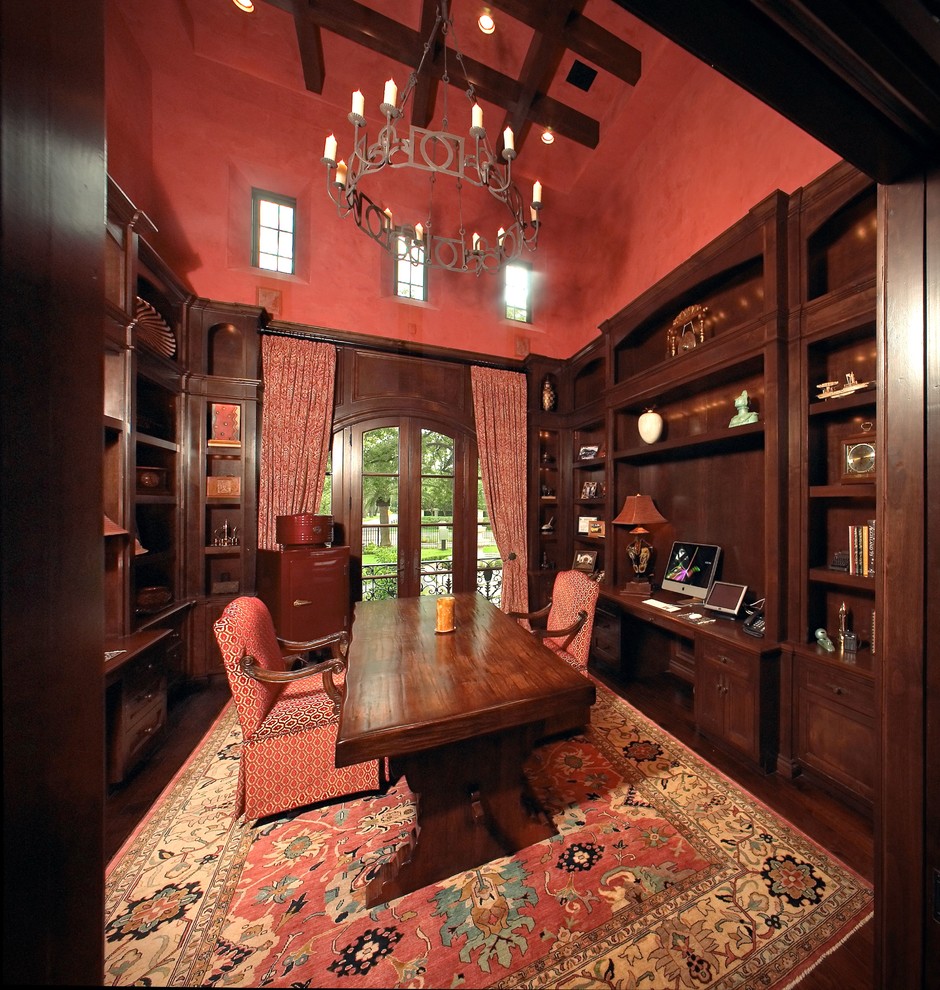 На фото: кабинет среднего размера в средиземноморском стиле с красными стенами и отдельно стоящим рабочим столом
