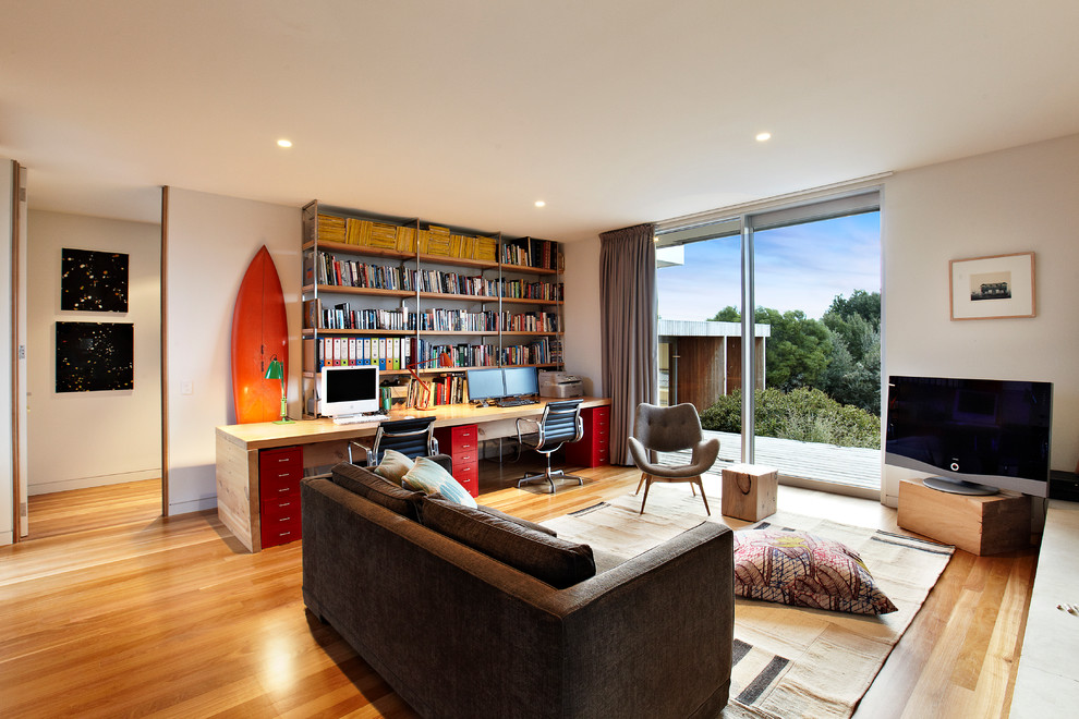 Large contemporary study in Melbourne with white walls, light hardwood flooring and a freestanding desk.