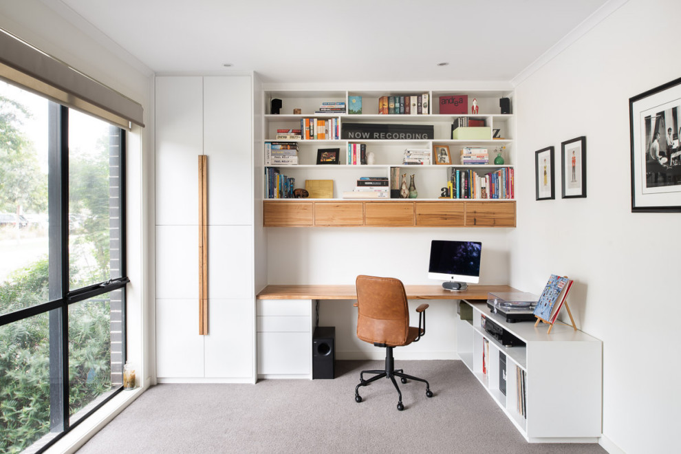 Inspiration för ett mellanstort funkis hemmabibliotek, med vita väggar, heltäckningsmatta, ett inbyggt skrivbord och grått golv
