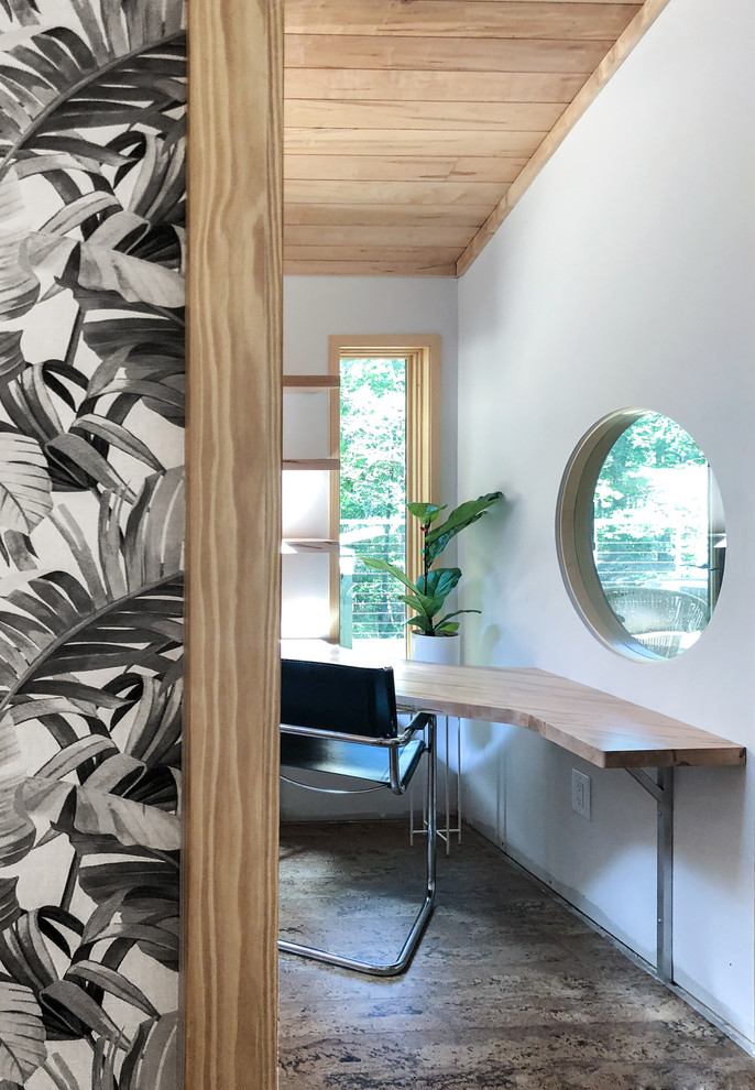 Foto di uno studio minimal di medie dimensioni con pareti bianche, pavimento in sughero, scrivania incassata e pavimento marrone