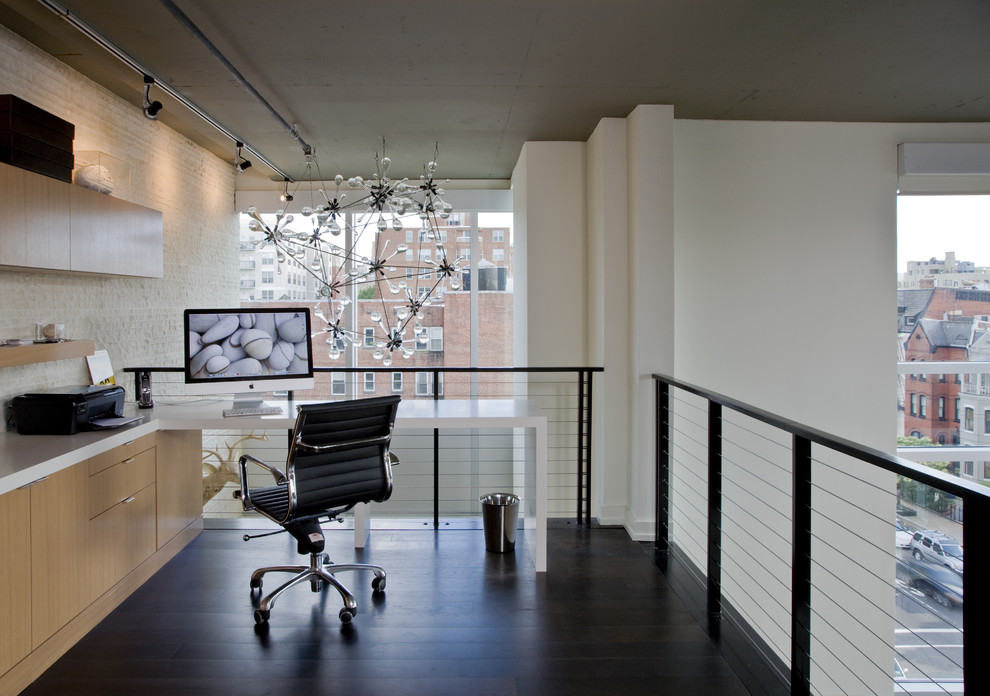 Foto di uno studio industriale con pareti bianche, parquet scuro e scrivania incassata