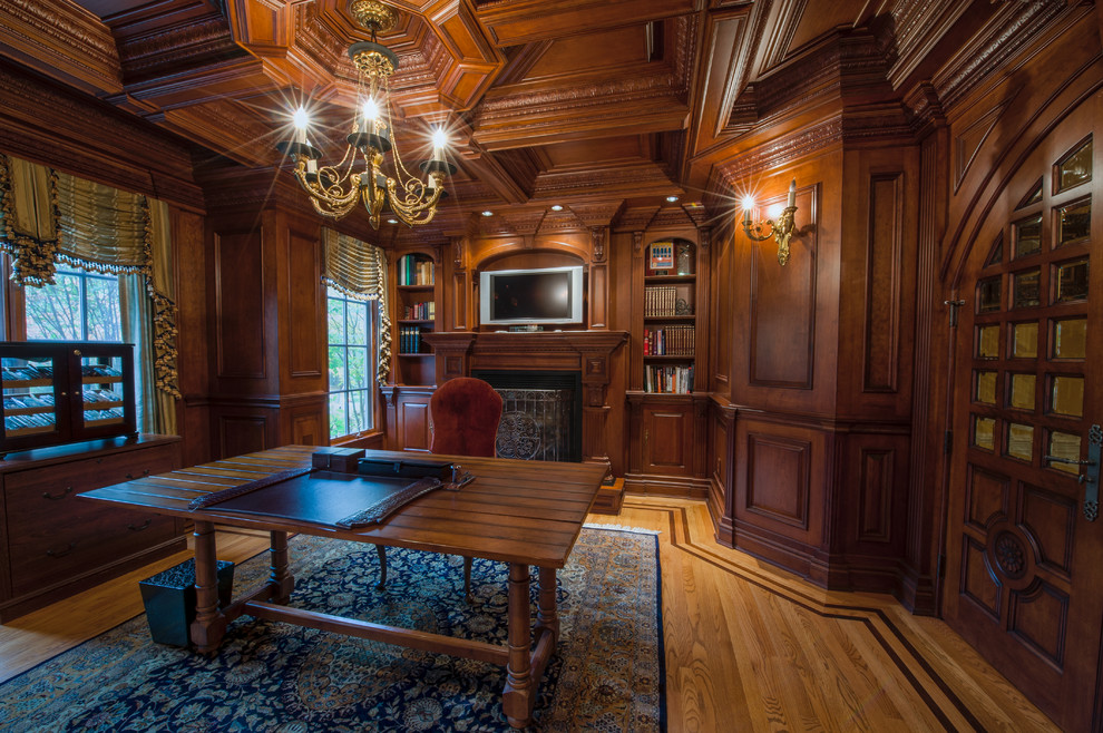 Foto de despacho clásico grande con suelo de madera en tonos medios y escritorio independiente