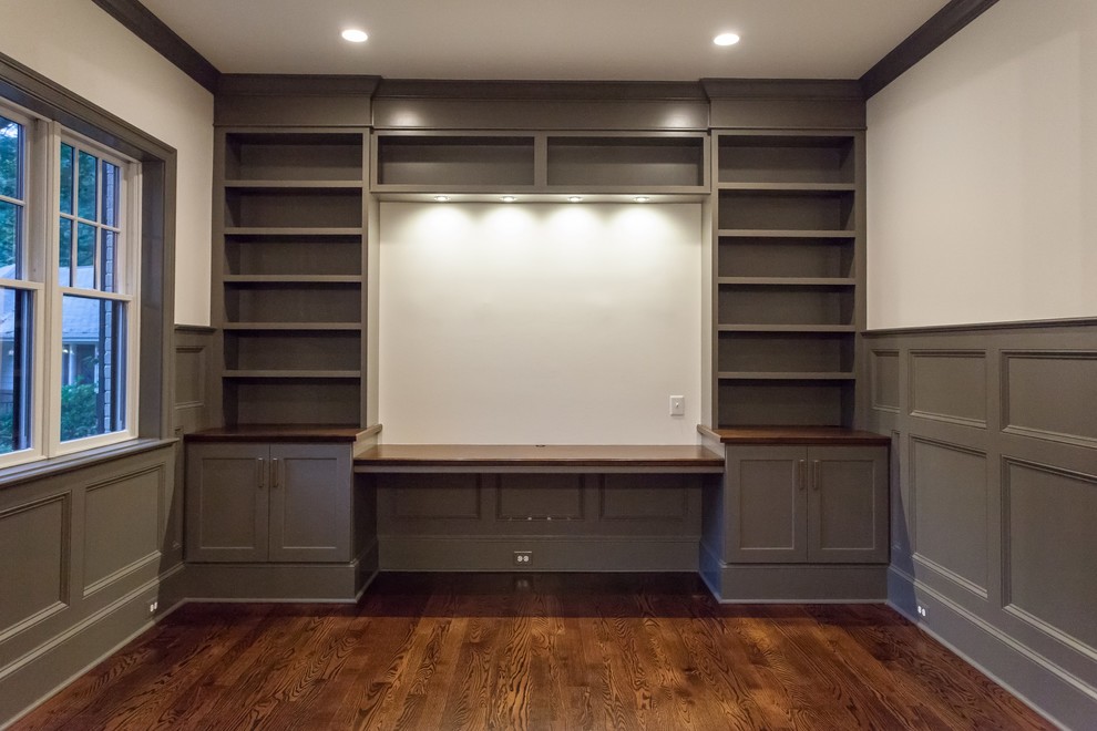 Idéer för att renovera ett vintage hemmabibliotek, med vita väggar, mellanmörkt trägolv, ett inbyggt skrivbord och brunt golv