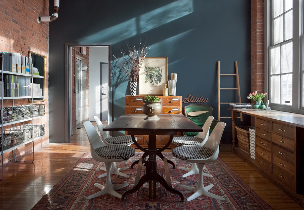 Aménagement d'un bureau industriel de taille moyenne et de type studio avec un mur bleu, un sol en bois brun, un bureau indépendant et un sol marron.