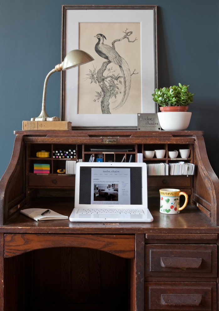Cette photo montre un bureau craftsman de taille moyenne et de type studio avec un mur bleu, un sol en bois brun, un bureau indépendant et un sol marron.