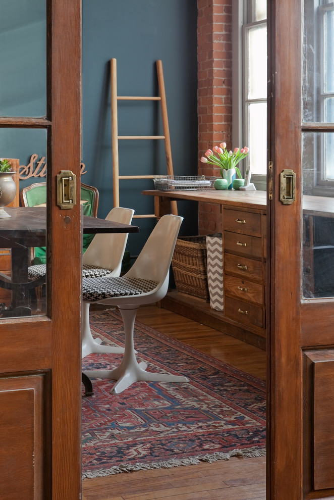 Mid-sized urban freestanding desk medium tone wood floor and brown floor home studio photo in Boston with blue walls