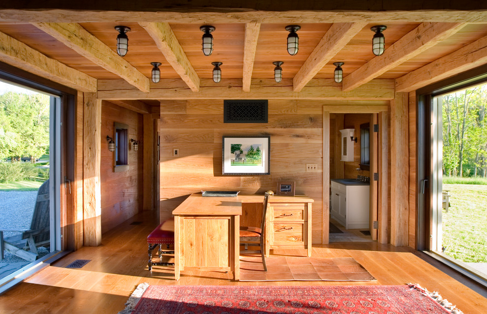 Imagen de despacho de estilo de casa de campo con paredes marrones, suelo de madera en tonos medios y escritorio independiente
