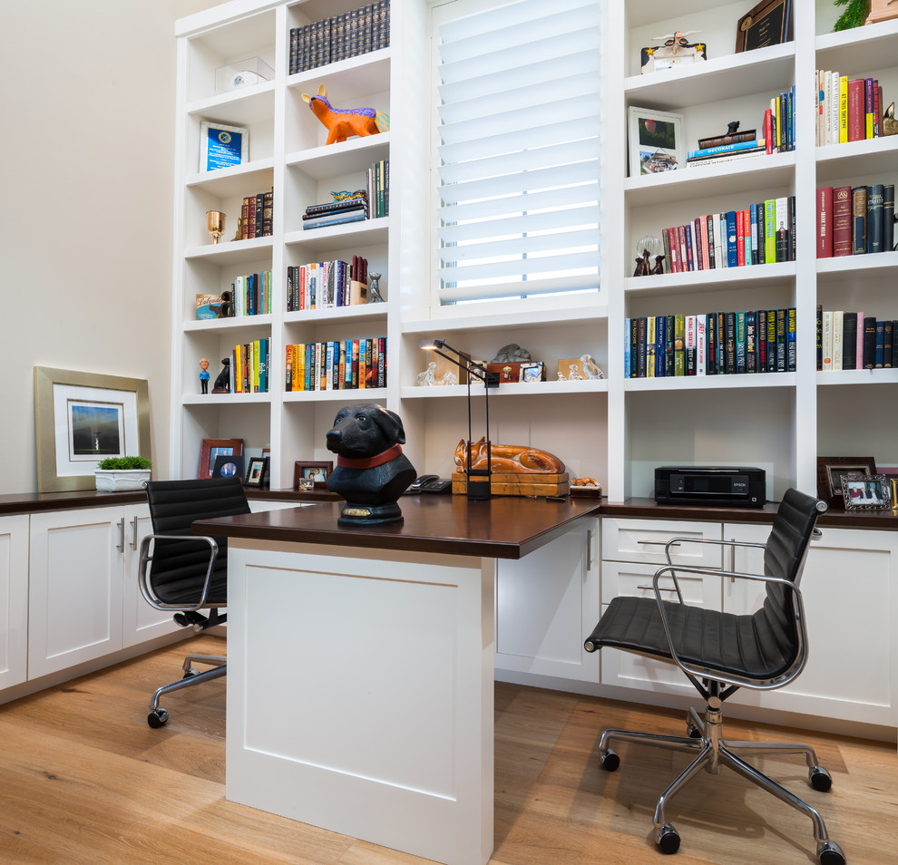 Klassisches Arbeitszimmer mit beiger Wandfarbe, Einbau-Schreibtisch und hellem Holzboden in Sonstige