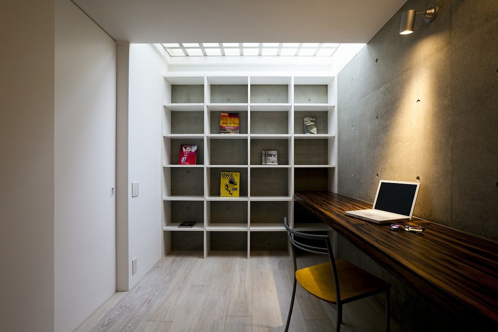 東京23区にあるインダストリアルスタイルのおしゃれなホームオフィス・書斎 (マルチカラーの壁、塗装フローリング、造り付け机、グレーの床) の写真