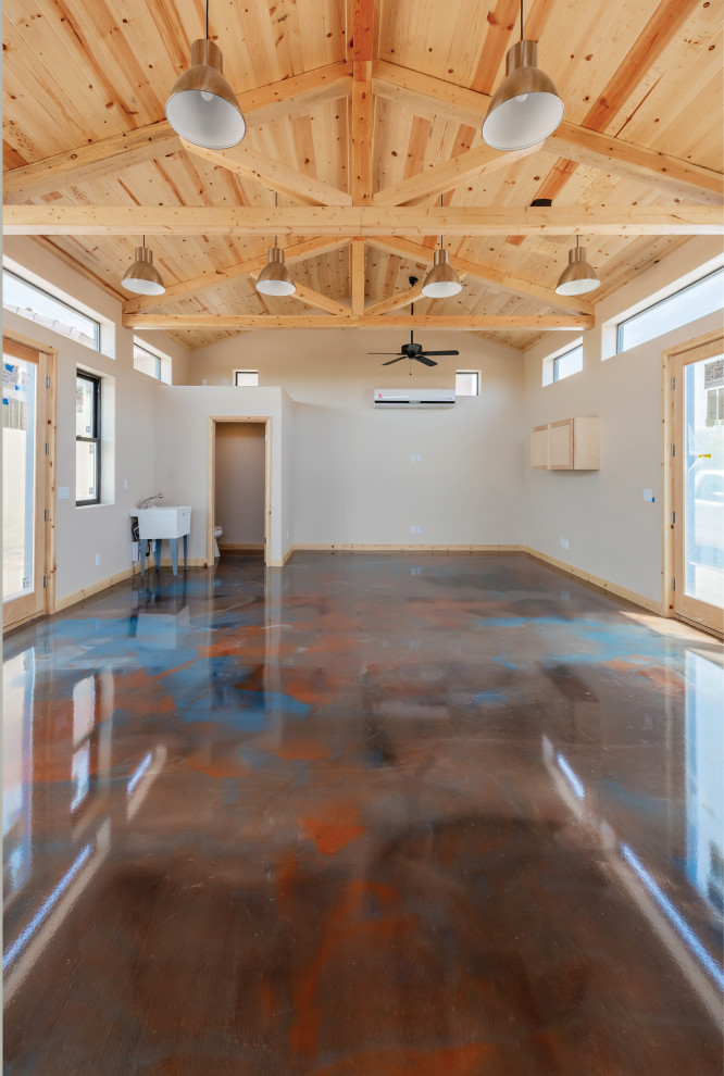 Cette image montre un grand bureau atelier craftsman avec un mur beige, sol en béton ciré et un sol multicolore.