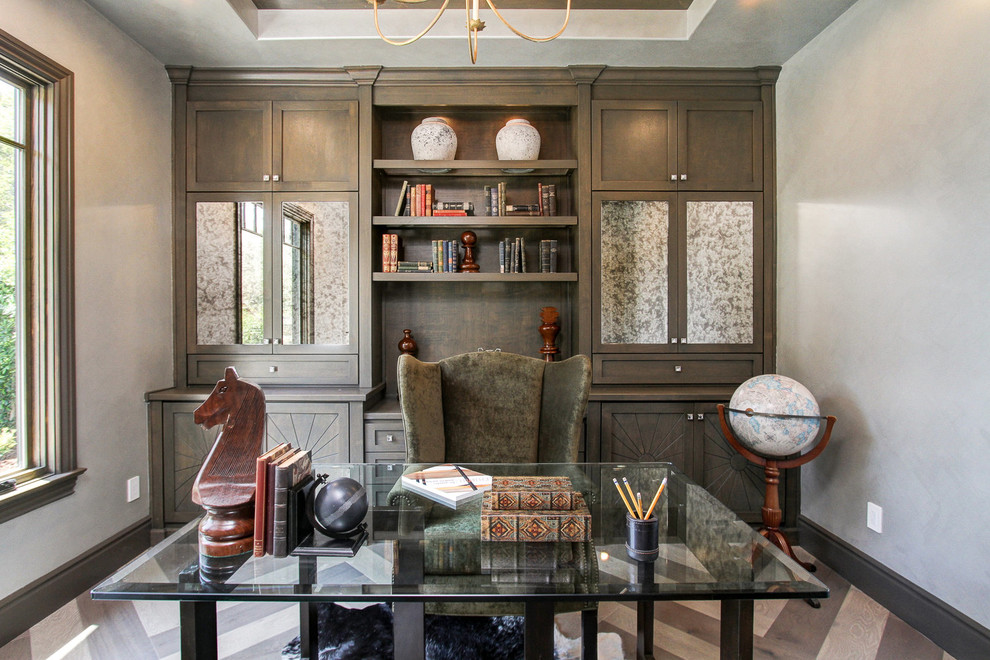Diseño de despacho tradicional con paredes grises, escritorio independiente y suelo marrón