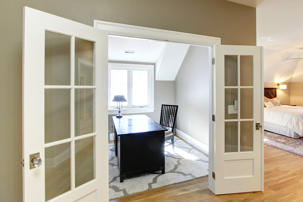 Photo of a large classic study in Denver with beige walls, light hardwood flooring and a freestanding desk.