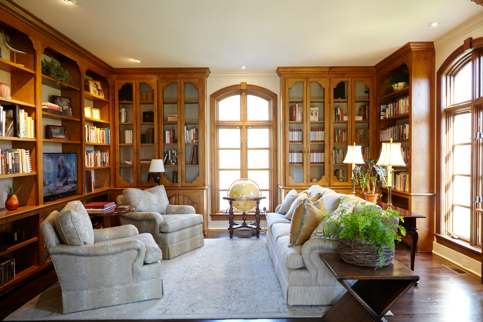 Idéer för att renovera ett stort vintage arbetsrum, med ett bibliotek, beige väggar, mörkt trägolv och brunt golv