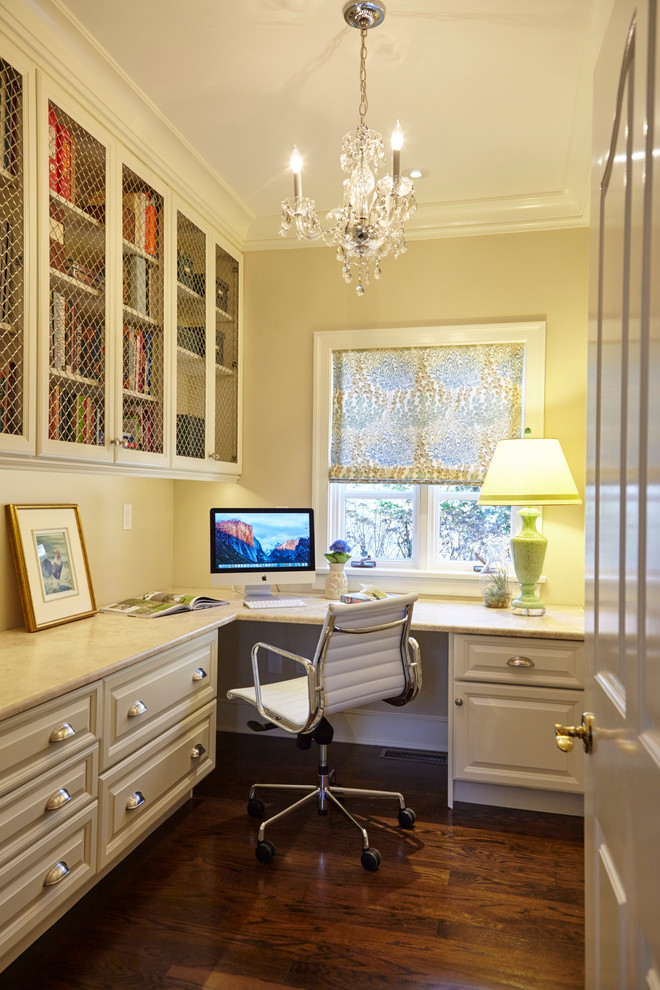Exemple d'un grand bureau chic avec un mur beige, parquet foncé, aucune cheminée, un bureau intégré et un sol marron.