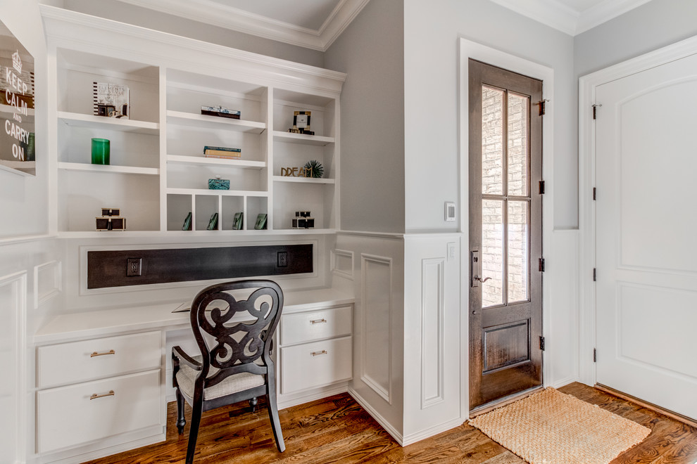 Traditional home office in Raleigh with grey walls, medium hardwood flooring and brown floors.