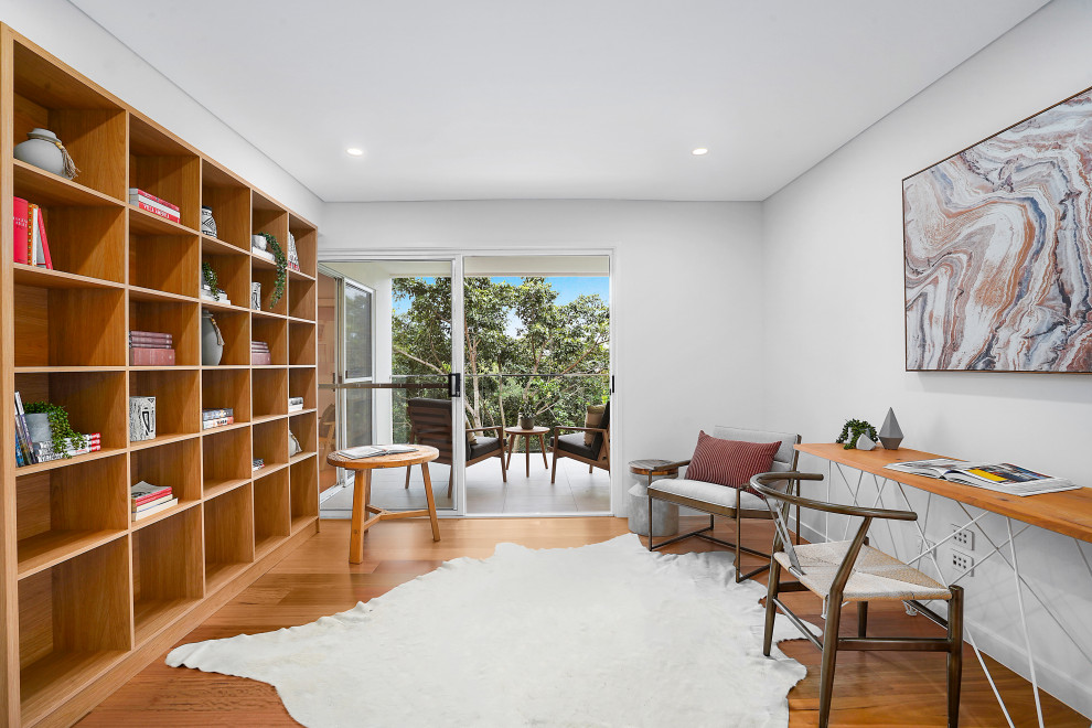 Immagine di un grande ufficio minimal con pareti bianche, scrivania autoportante e pavimento marrone