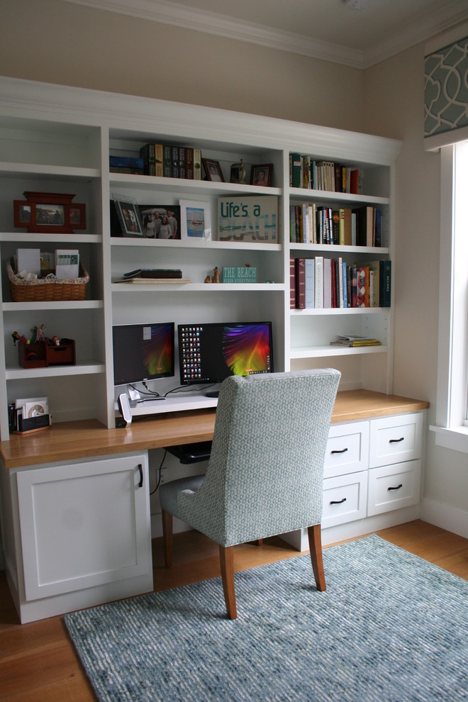 Imagen de despacho clásico renovado pequeño con paredes blancas, suelo de piedra caliza, escritorio empotrado y suelo marrón
