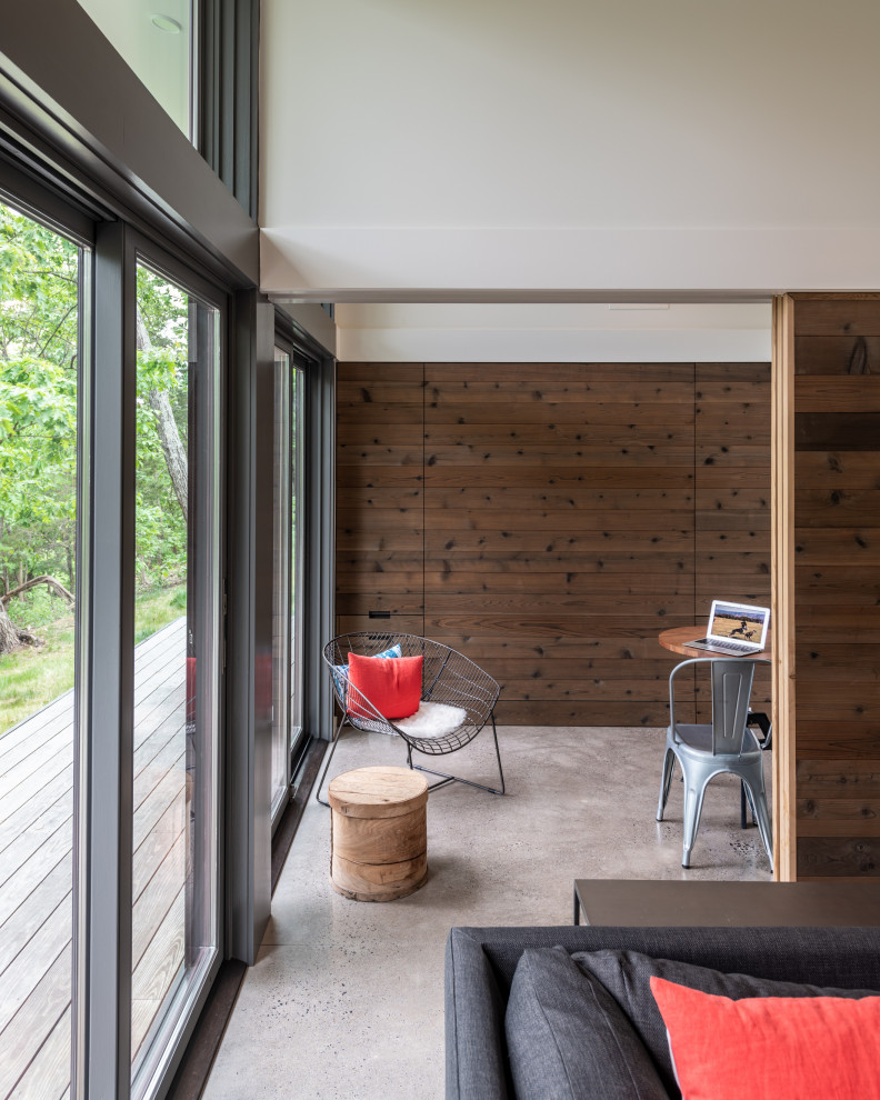 Aménagement d'un petit bureau moderne avec sol en béton ciré, un manteau de cheminée en béton et un sol gris.