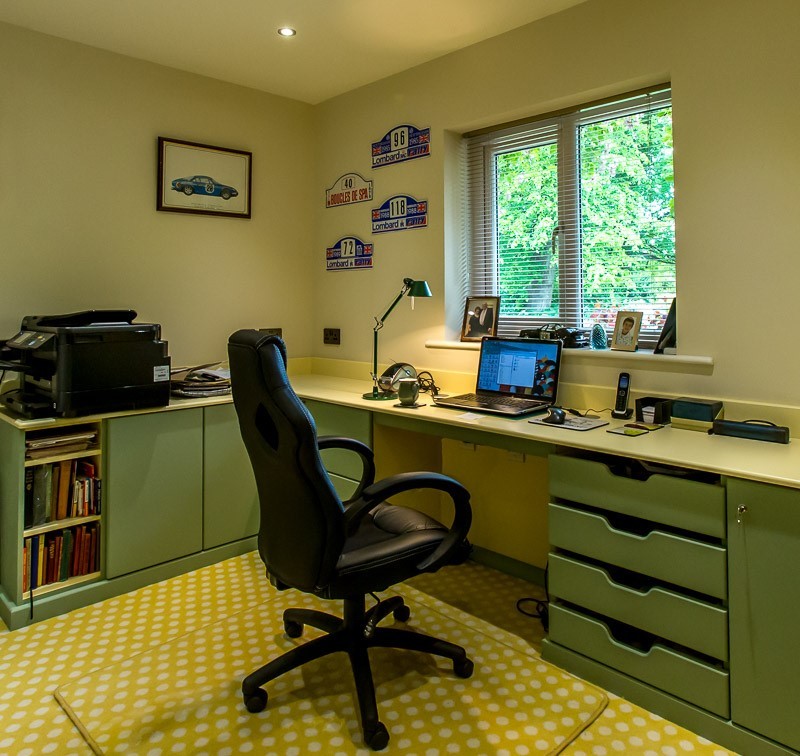 Foto de despacho clásico renovado de tamaño medio con paredes amarillas, moqueta y escritorio empotrado