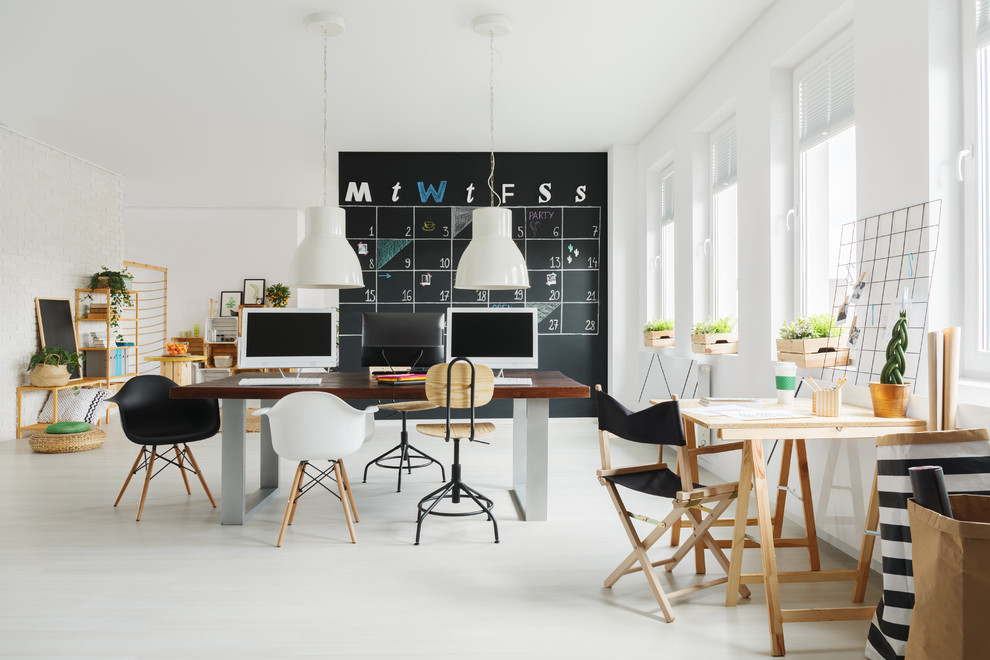 На фото: домашняя мастерская среднего размера в скандинавском стиле с белыми стенами, бетонным полом, отдельно стоящим рабочим столом и серым полом без камина