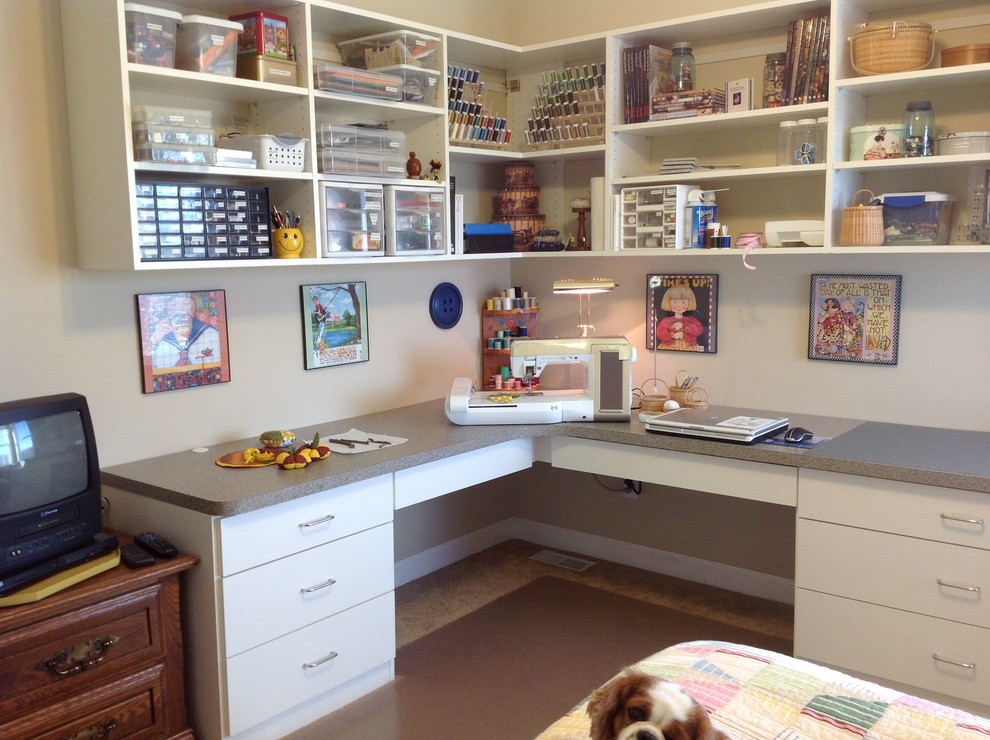 Foto på ett mellanstort funkis hobbyrum, med vita väggar och ett inbyggt skrivbord